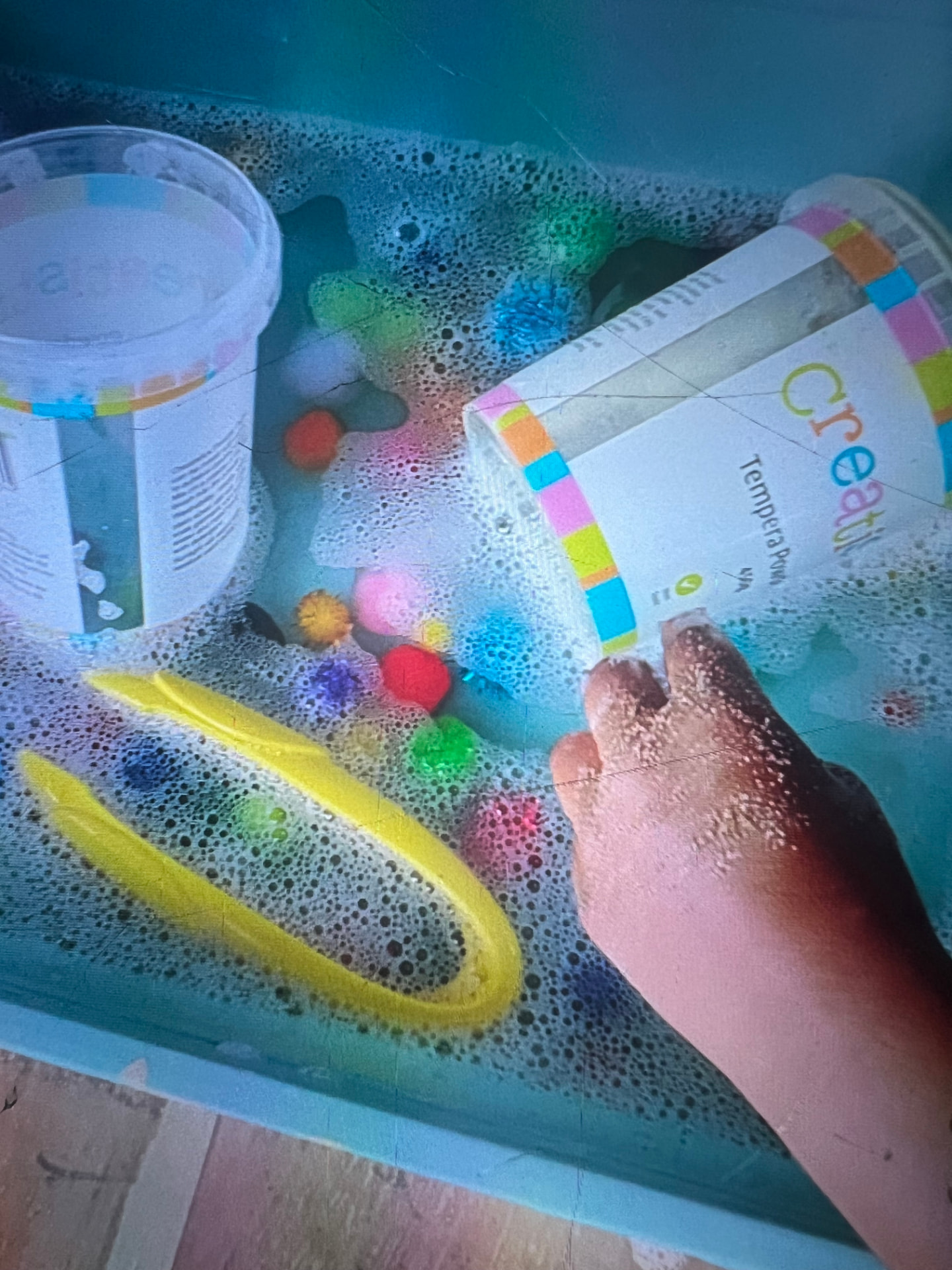 Tempera powder poured into a foamy sensory tray