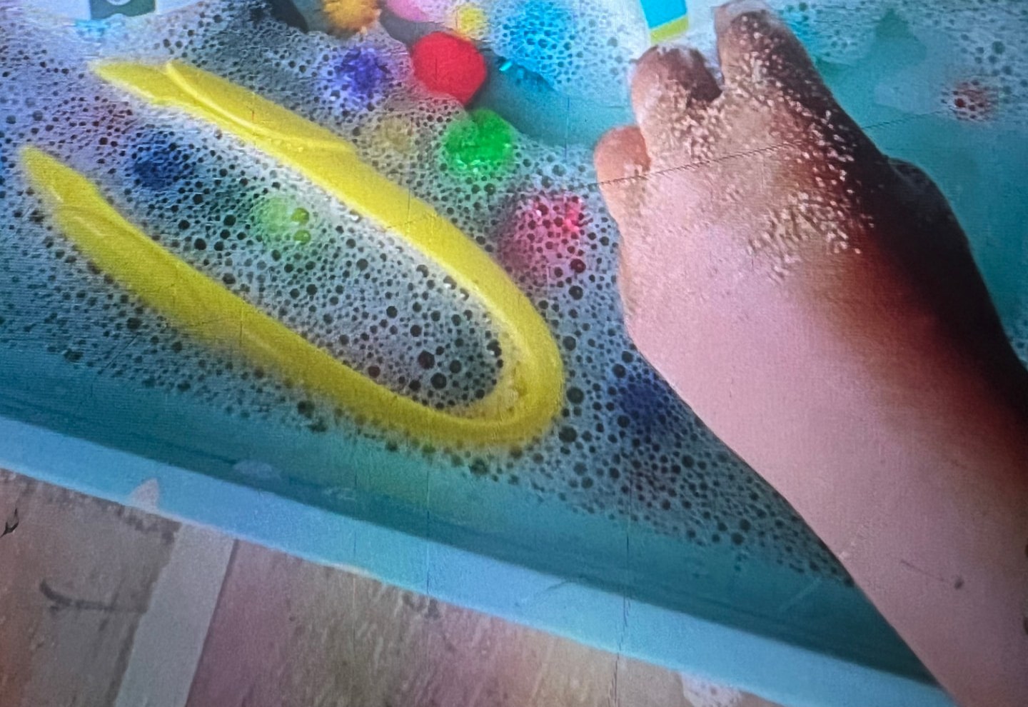 The foam tray set up with pom-poms, scoops and cups